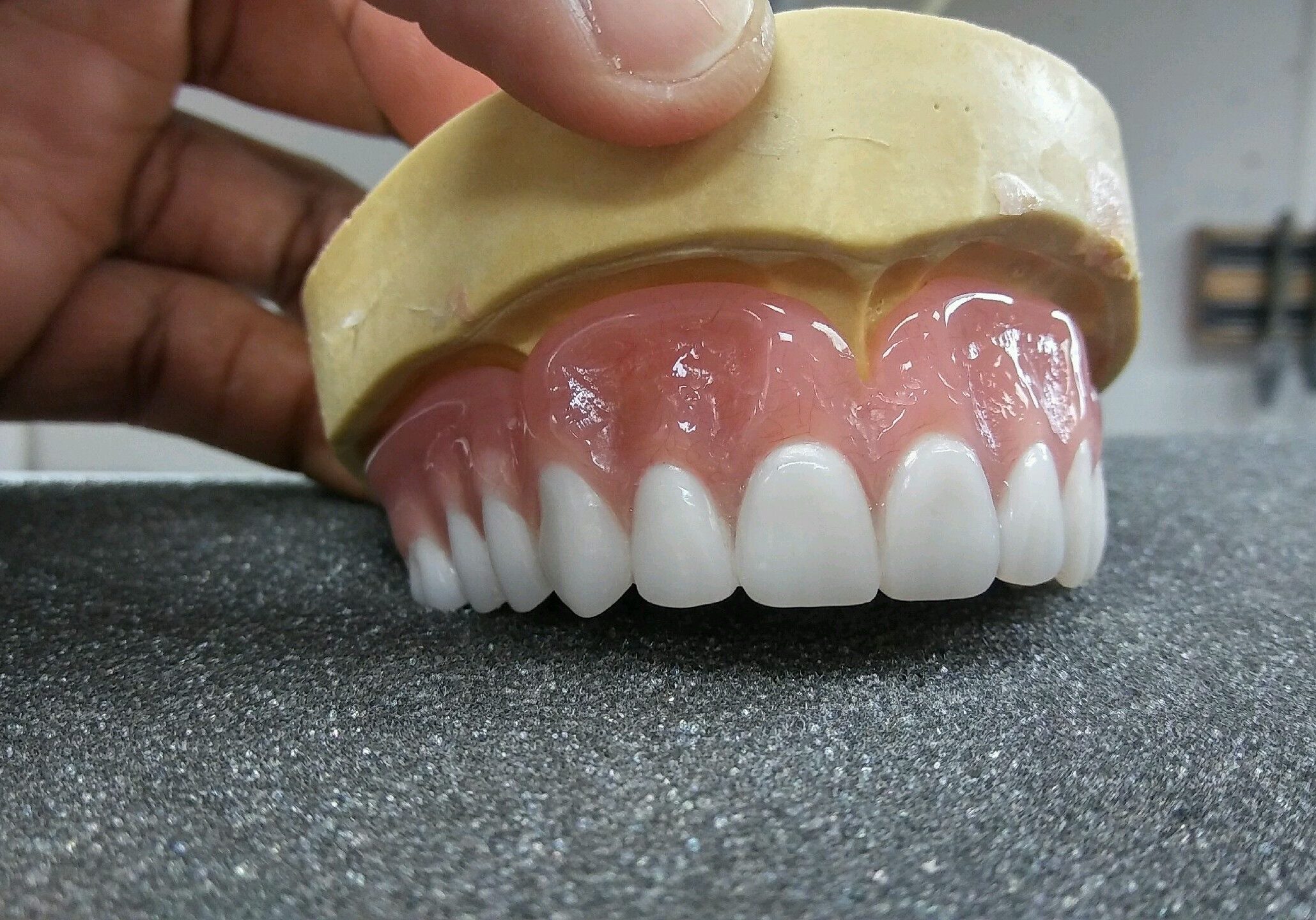 72237ca2-d718-4261-bcc6-573a5d87a837 A person holding onto the bottom of a fake denture.