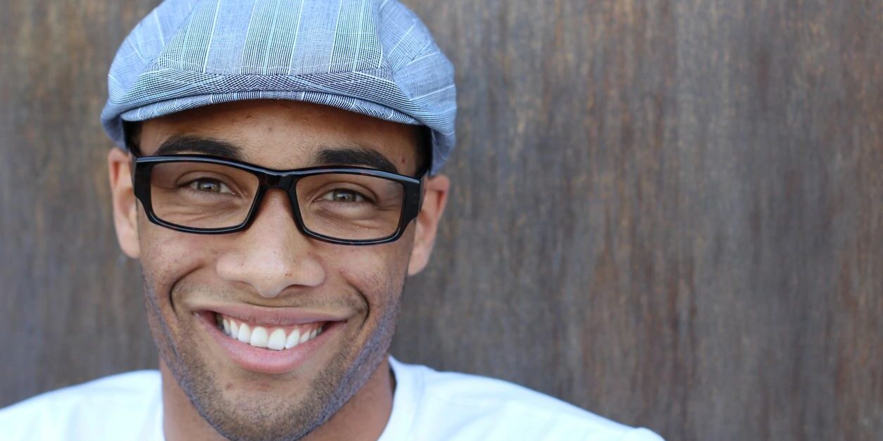 fm=f_Rrp6oAV A man wearing glasses and a hat smiling.